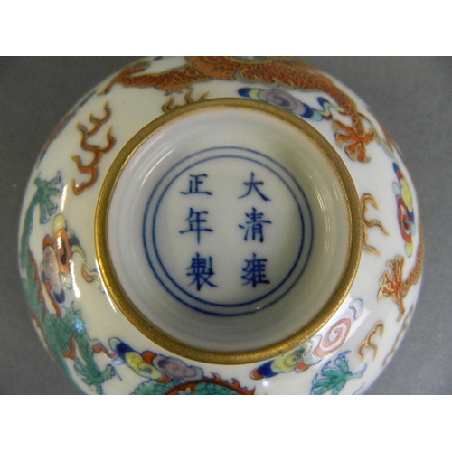 211 - A Chinese Doucai enamelled porcelain rice bowl decorated with twin dragons chasing the flaming pearl... 