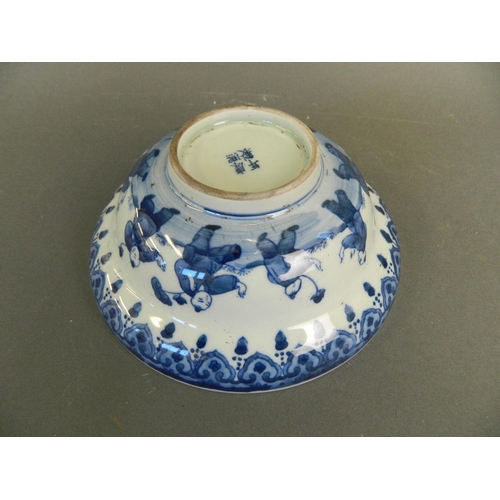 218 - A Chinese blue and white porcelain bowl decorated with nine boys playing in a garden and twin kylin ... 