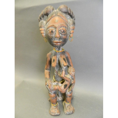 248 - An African carved wood tribal figure of a woman and child, 18