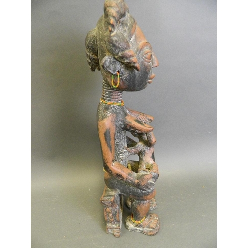 248 - An African carved wood tribal figure of a woman and child, 18