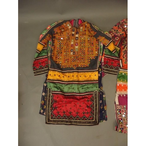 250A - A collection of three Middle Eastern lady's silk dresses with mirror bead and embroidered decoration... 