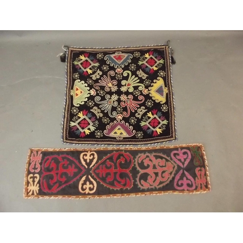 250N - An Uzbek black ground wall hanging with silk embroidered decoration, together with another similar, ... 