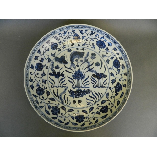 259 - A large Chinese blue and white pottery charger with painted carp and lotus flower decoration, 15½