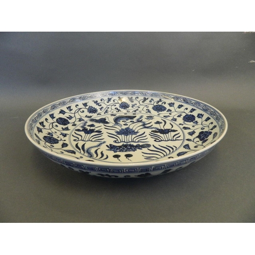 259 - A large Chinese blue and white pottery charger with painted carp and lotus flower decoration, 15½