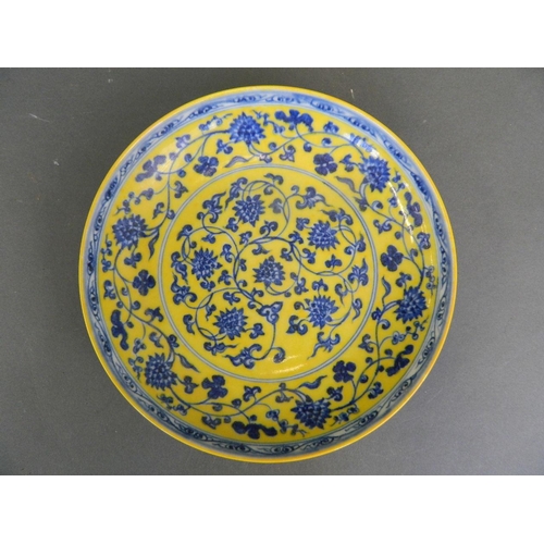 263 - A Chinese yellow ground porcelain dish with blue and white scrolling lotus flower decoration, 6 char... 