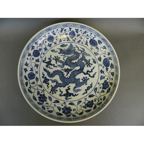 266 - A large Chinese blue and white pottery charger with painted dragon and lotus flower decoration, 6 ch... 