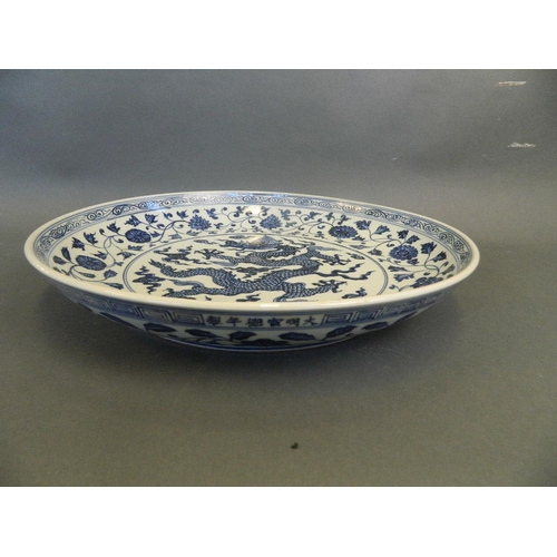 266 - A large Chinese blue and white pottery charger with painted dragon and lotus flower decoration, 6 ch... 