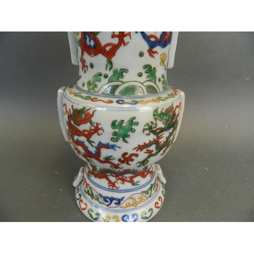 271 - A Chinese Wucai enamelled Gu shaped porcelain vase decorated with dragons chasing the flaming pearl,... 