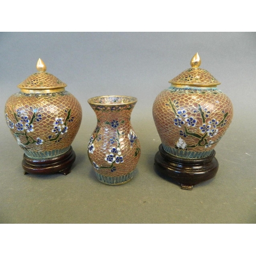 272 - A pair of Oriental plique-à-jour lidded urns on hardwood stands, and a similar baluster vase, 3½