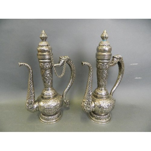 277 - A pair of Eastern mixed metal ewers with dragon spout, serpent handle and repoussé waterfowl decorat... 