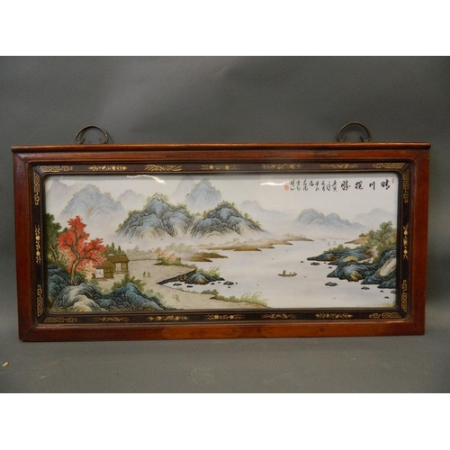 284 - A Chinese famille verte enamelled porcelain panel depicting an extensive landscape with riverside dw... 