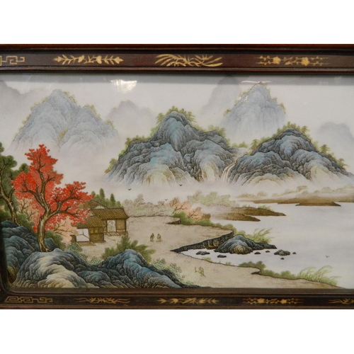 284 - A Chinese famille verte enamelled porcelain panel depicting an extensive landscape with riverside dw... 