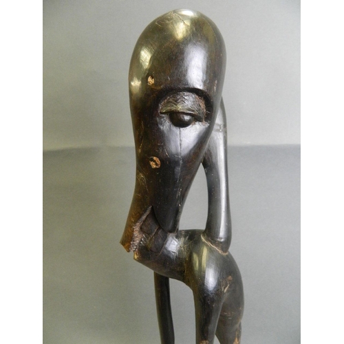 292 - An African ebonised hardwood abstract carving of a figure, 24½