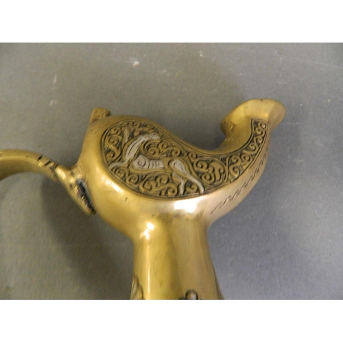 50X - An Islamic polished bronze pourer with silver inlaid decoration, 8½