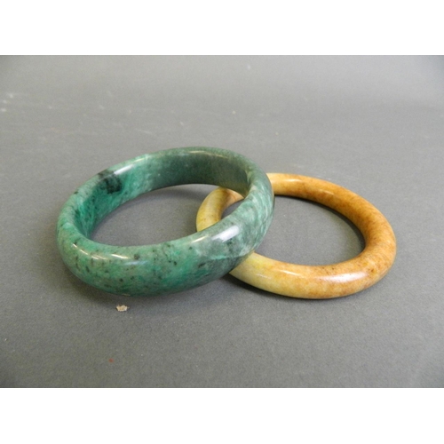 69 - A Chinese marbled green hardstone bangle, and another similar, 3