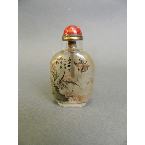 71 - A Chinese glass snuff bottle with reverse painted decoration with birds in flight and flowers, 2½