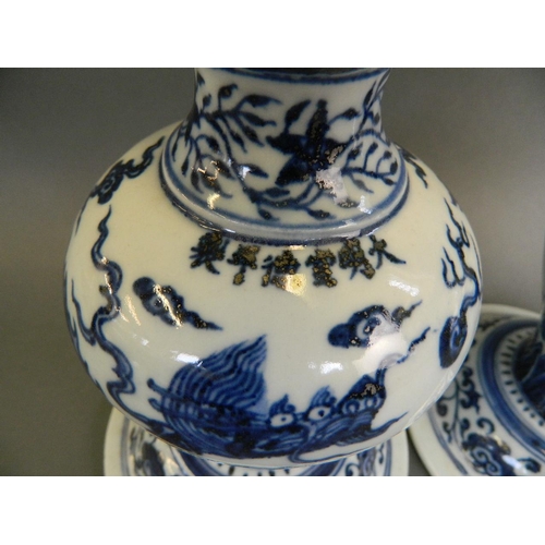 95 - A pair of Chinese blue and white porcelain vases of unusual form decorated with a dragon chasing the... 