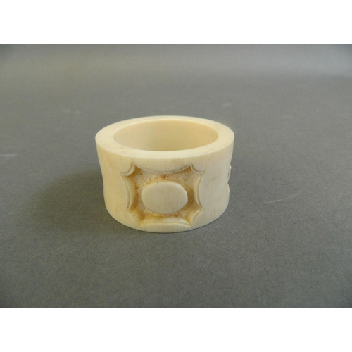 147 - A finely carved Cantonese ivory napkin ring with decorative panels depicting figures under cypress t... 