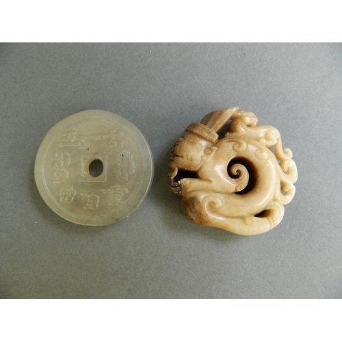 150 - A cream and brown hardstone pendant carved in the form of a votive figure, together with an opaque h... 