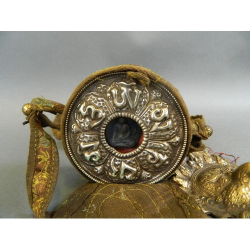 163 - A Sino-Tibetan travelling shrine in a cloth carry pouch, together with a brass mask pendant in the f... 