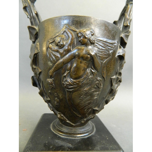 165 - A C19th twin handled bronze urn with relief classical decoration, mounted on a hardstone base, 7