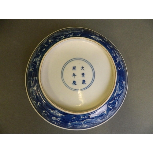 17 - A Chinese blue and white porcelain dish decorated with dragons chasing the flaming pearl, 6 characte... 