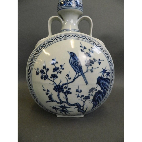 174 - A Chinese blue and white porcelain twin handled moonflask decorated with birds perched on a prunus b... 