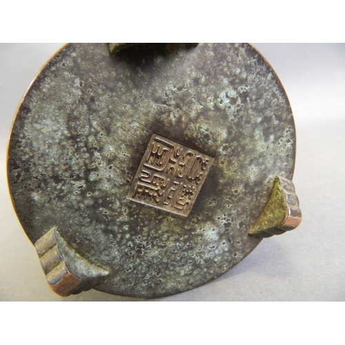 178 - A Chinese bronze censer with relief symbol decoration, on tripod bracket feet, seal mark to base, 4