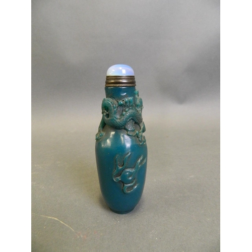 197 - A Chinese blue ground glass snuff bottle with carved dragon and flaming pearl decoration, 3½