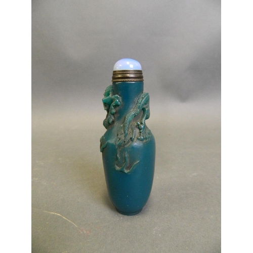 197 - A Chinese blue ground glass snuff bottle with carved dragon and flaming pearl decoration, 3½