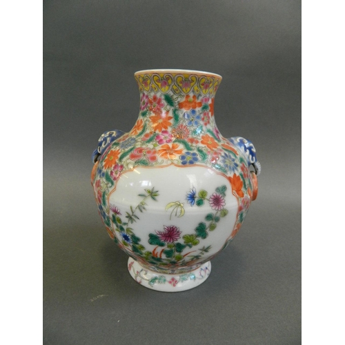 198 - A Chinese polychrome porcelain vase with twin elephant mask handles and painted decoration of butter... 