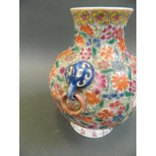 198 - A Chinese polychrome porcelain vase with twin elephant mask handles and painted decoration of butter... 