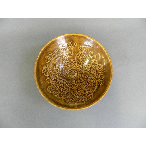 20 - A Chinese brown glazed pottery dish with incised scrolling decoration, 6½