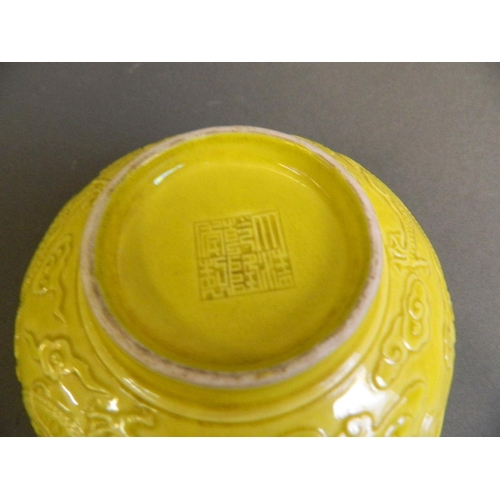 223 - A Chinese yellow glazed porcelain bowl with relief dragon and flaming pearl decoration, seal mark to... 