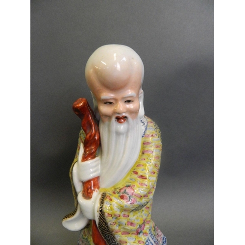 240 - A Chinese polychrome enamelled porcelain figure of Yue Lao, mounted on a carved hardwood base, 10