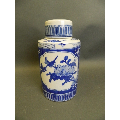 250F - A Chinese blue and white porcelain tea canister with decorative panels depicting riverside temples a... 