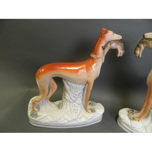 256 - A pair of large Staffordshire pottery figures of greyhounds with game, 11