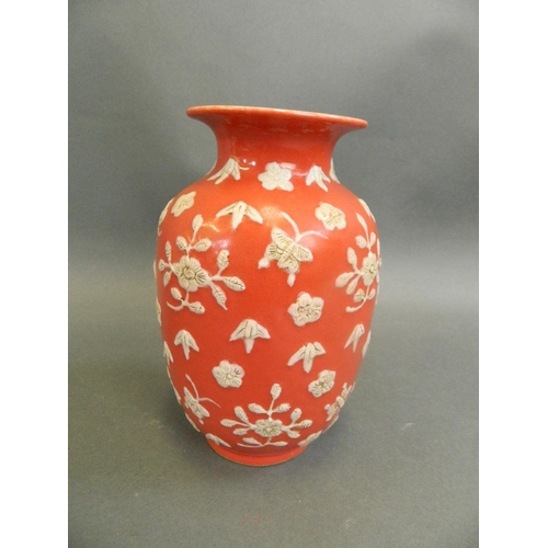 266 - A Chinese red ground vase with white enamel butterfly and floral decoration, 6 character mark to bas... 