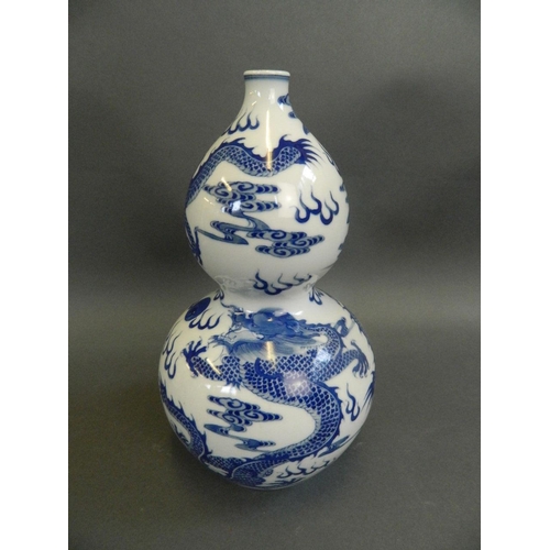 267 - A Chinese blue and white porcelain double gourd vase decorated with dragons chasing the flaming pear... 