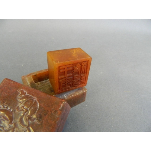 29 - A Chinese red soapstone box with engraved decoration of carp to lid, and amber soapstone seal within... 