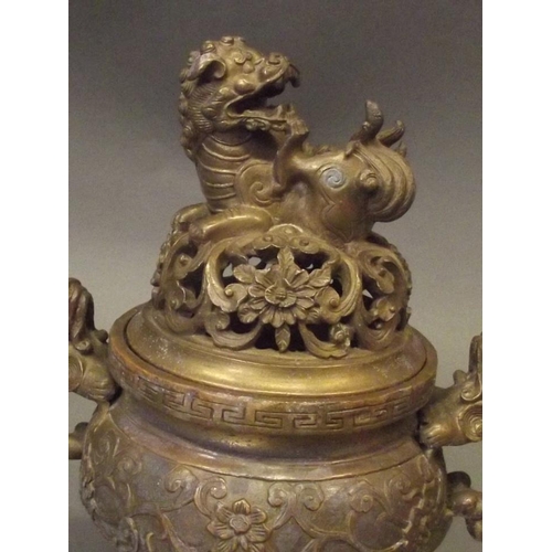 350T - A Chinese bronze censer with twin kylin handles, the pierced cover with kylin knop, raised on tripod... 