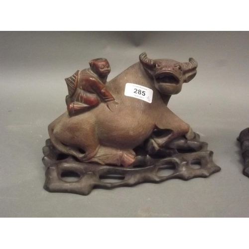 350U - A pair of Chinese carved stained wood figures of young boys riding water buffalo, on pierced wood st... 