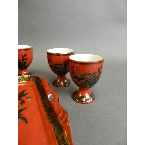 350W - A Chinese red ground porcelain wine ewer with matching cups, together with a similar tray with black... 