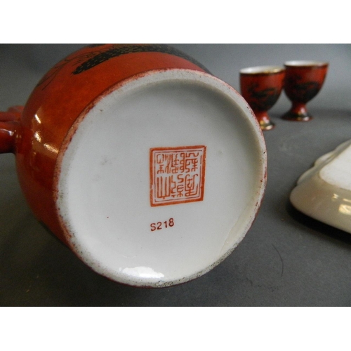 350W - A Chinese red ground porcelain wine ewer with matching cups, together with a similar tray with black... 