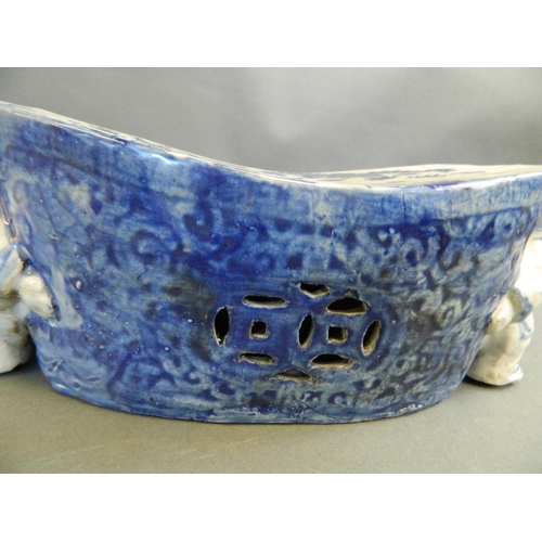 363 - A Chinese blue and white porcelain pillow decorated with dragons, supported by two boys, 12