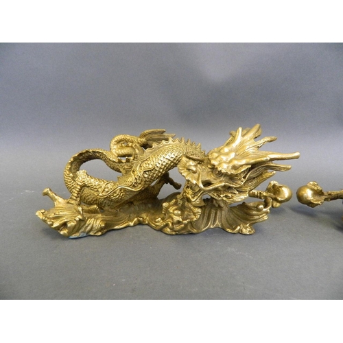 383 - A pair of Chinese gilt metal scroll weights in the form of dragons, 7½