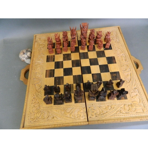 417 - A complete chess set with unusually carved pieces in the form of mythical beasts, in a decorative ca... 