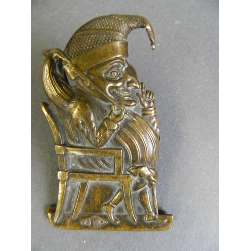 425E - A Victorian brass money clip in the form of Mr Punch seated in an armchair, with detailed engraved d... 