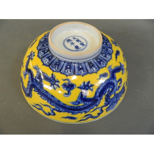 432 - A Chinese Ming style yellow ground porcelain bowl decorated with dragons chasing the flaming pearl i... 