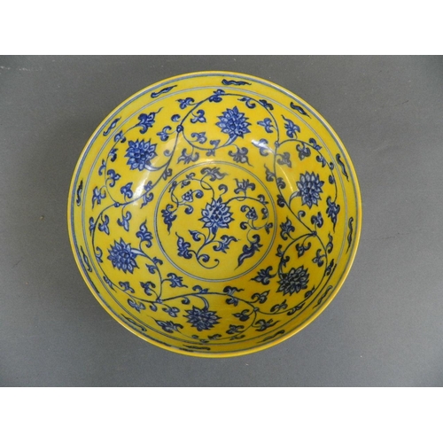 448 - A Chinese yellow ground porcelain bowl with blue and white scrolling lotus flower decoration, 6 char... 